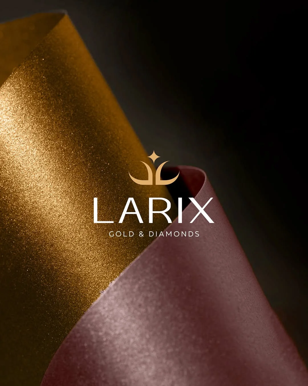 Larix Gold & Diamonds logo in white and gold over folded satin paper in gold and plum