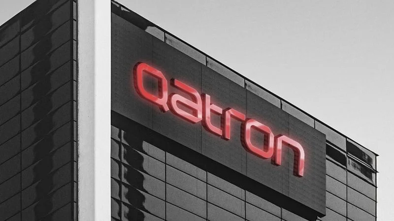 Red Qatron channel letters on a dark building facade